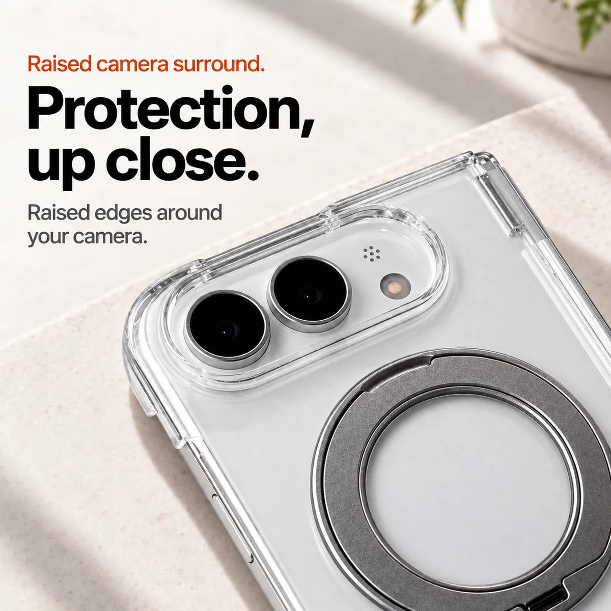Clear phone case close-up showing the raised oval camera surround and folded ring. #color_Pure Crystal